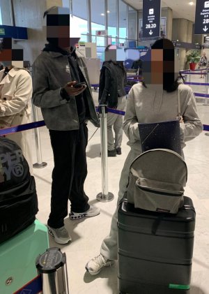 Cette image montre deux élèves avec leurs bagages attendant l'embarquement
